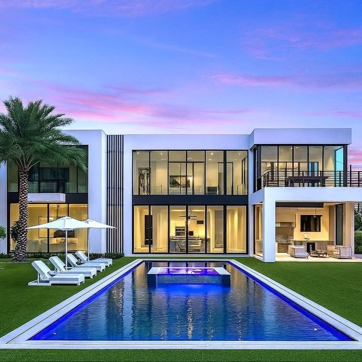 Modern two-storey home at dusk with pool and landscaped grounds